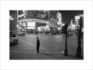 Lone man in Piccadilly at night; 1960