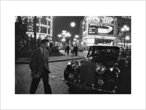 A man cuts across traffic at Piccadilly Circus; 1960