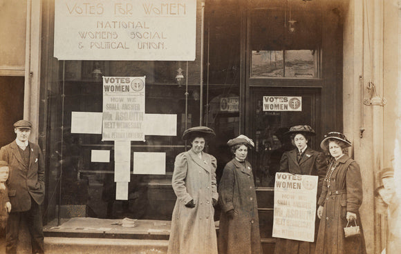 Photographic postcard of leading Suffragettes standing outside a branch shop of the Women's Social and Political Union in Hawick, Scotland.