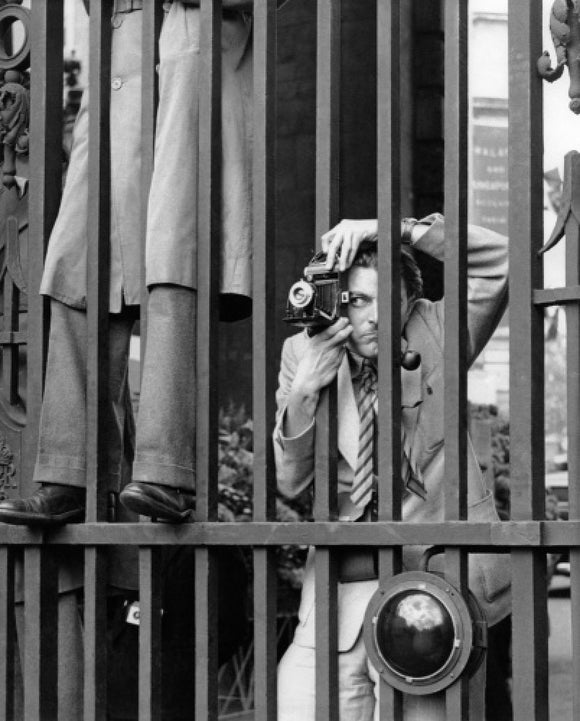 A photographer takes a picture through the railings at Admiralty Arch: 1953