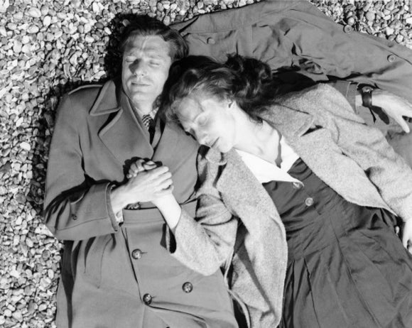 A couple lying together on Brighton Beach: c. 1955
