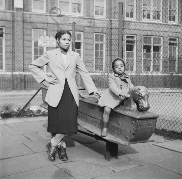 East London Afro-Caribbean child and mother in playground; 1952
