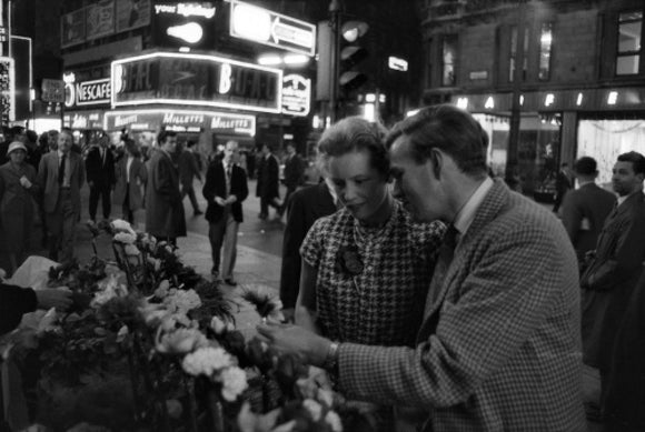 Man buying a woman a flower in the West End: 1960