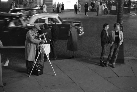 Photographer recording the nightlife; c.1960