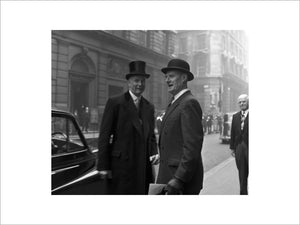 Three formally dressed men on a street flanked by high buildings. c.1955