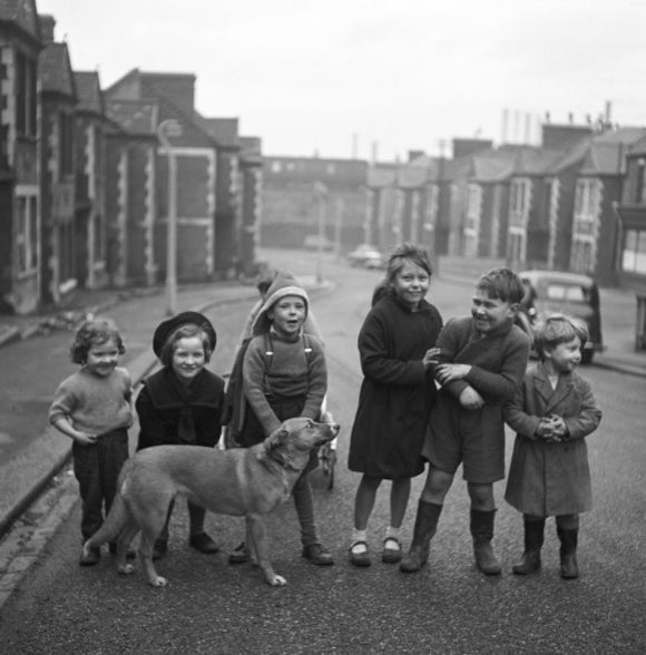 Children gathered in street with dog. c.1955